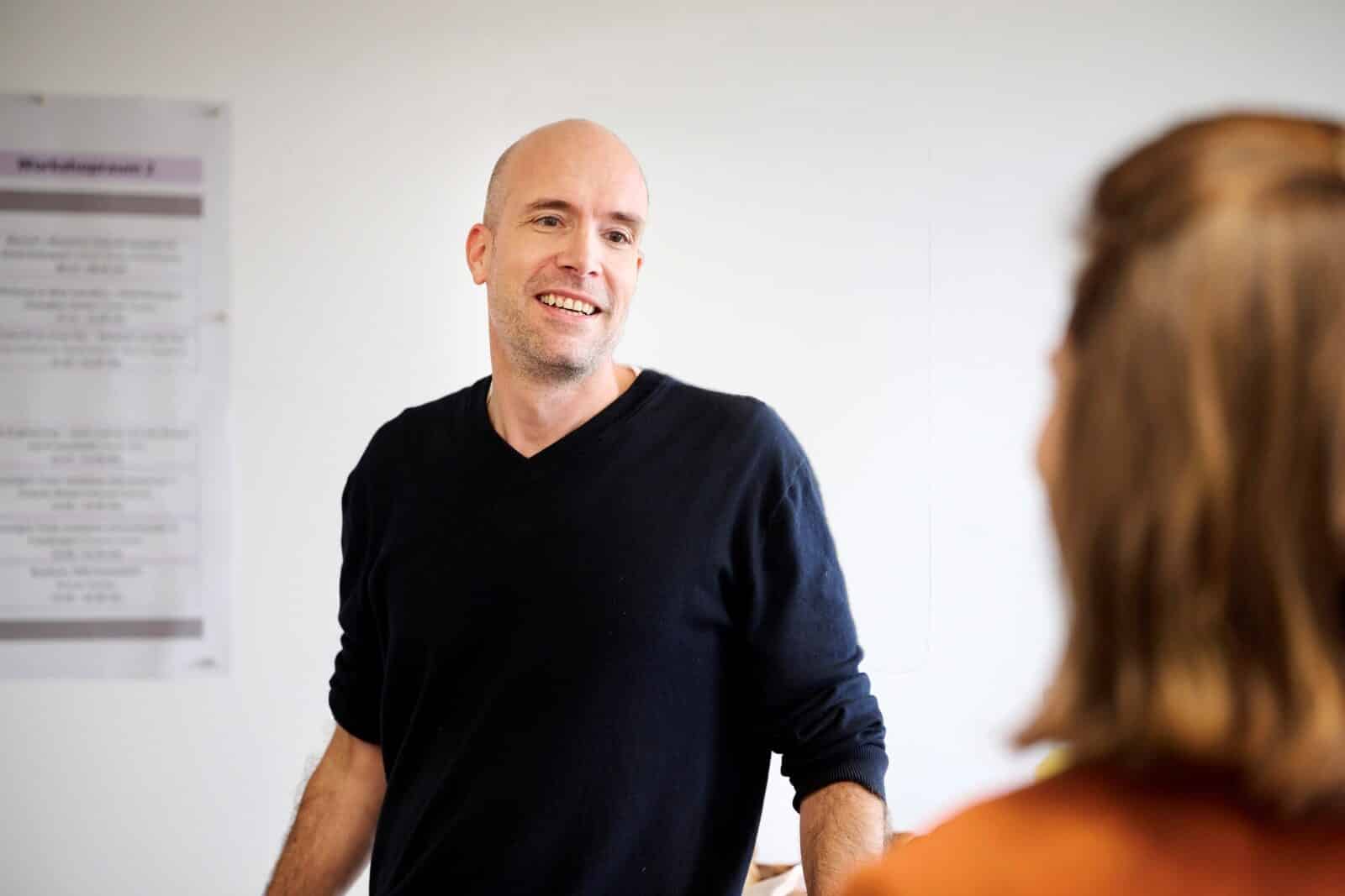 Trainer erklärt Resilienz- und Herzkohärenztraining in einem Workshop für Mitarbeitende und Führungskräfte.